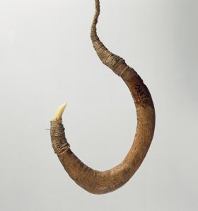 Fishhook with curved wooden shank, bone point, and lashing of twisted cords of plant material.