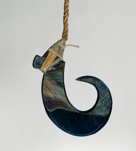 Fishhook made of a large dark purple pinna shell where strings made of various plant fibres are attached.