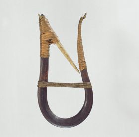 U-shaped wooden hook made with whale sinew and an inward pointing barbed bone tied to the hook with root splits.