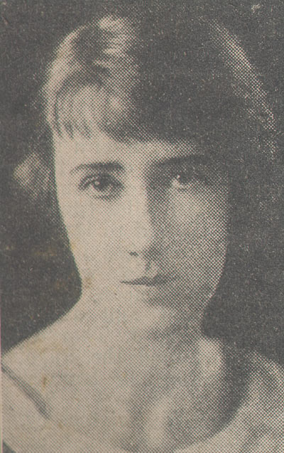 Photograph of a dark-haired woman gazing, unsmiling, at the camera - click to view larger image