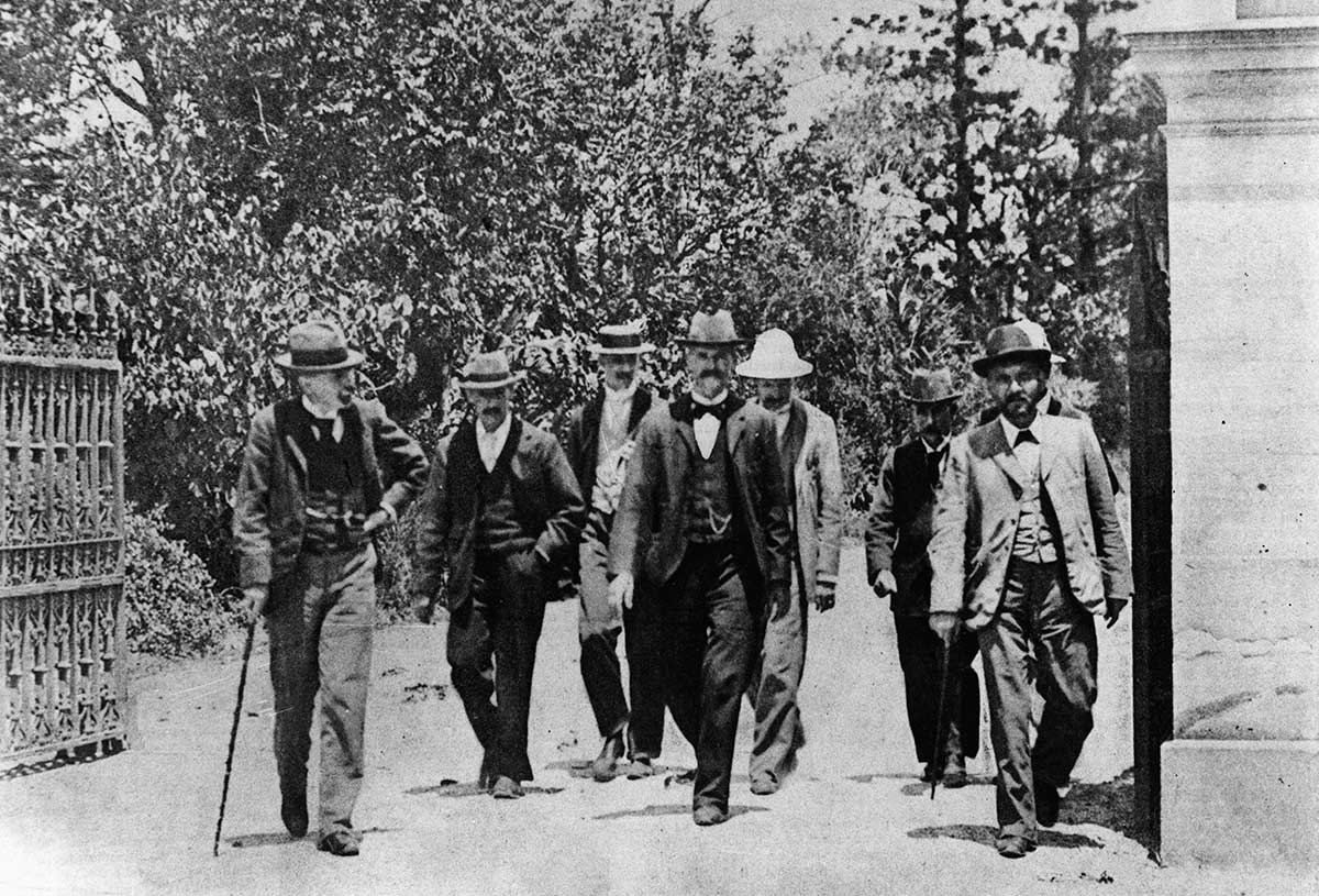 A group of men wearing suits and hats.