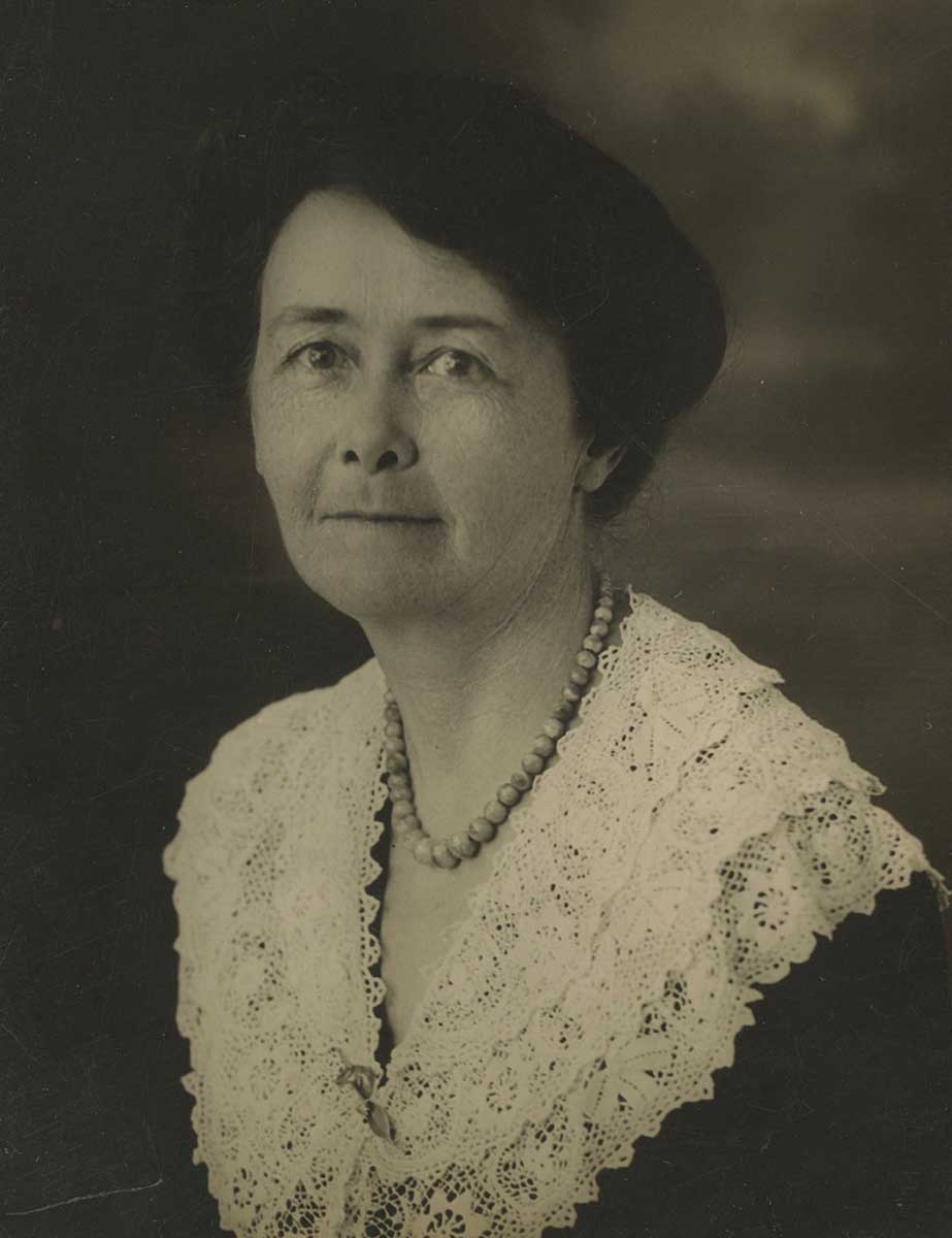 Studio photograph portrait of a smiling middle-aged woman.