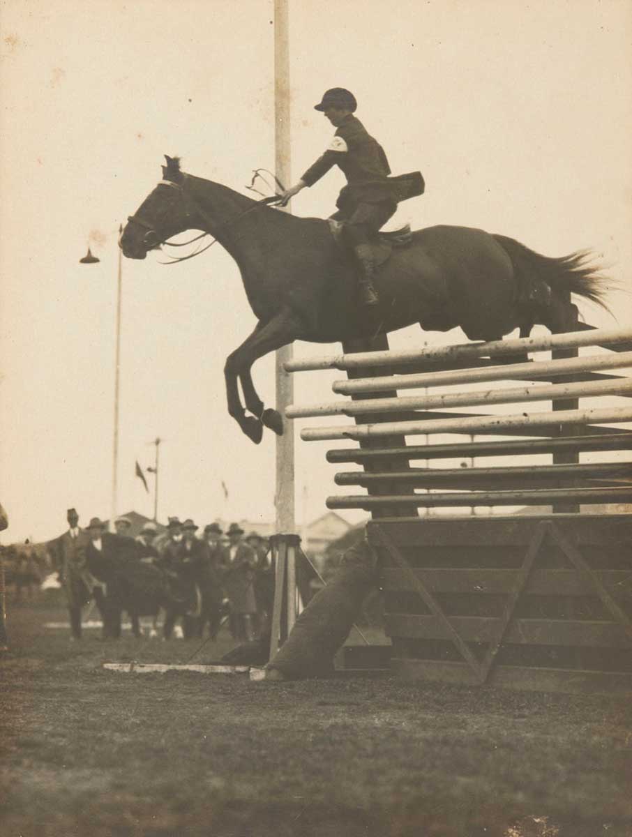 A black and white photograph of Emily Roach on mount 'Dungog' executing a jump. - click to view larger image