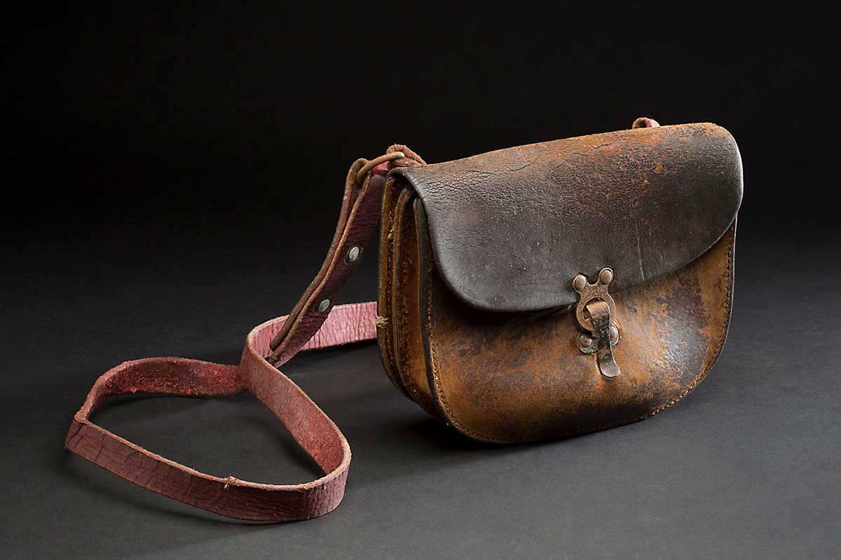 Brown leather bag with a shoulder strap, and metal clasp at the front. - click to view larger image