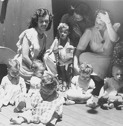 Black and white photo of three young mothers with six young children.