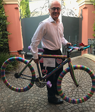 A male holding a colourful bike