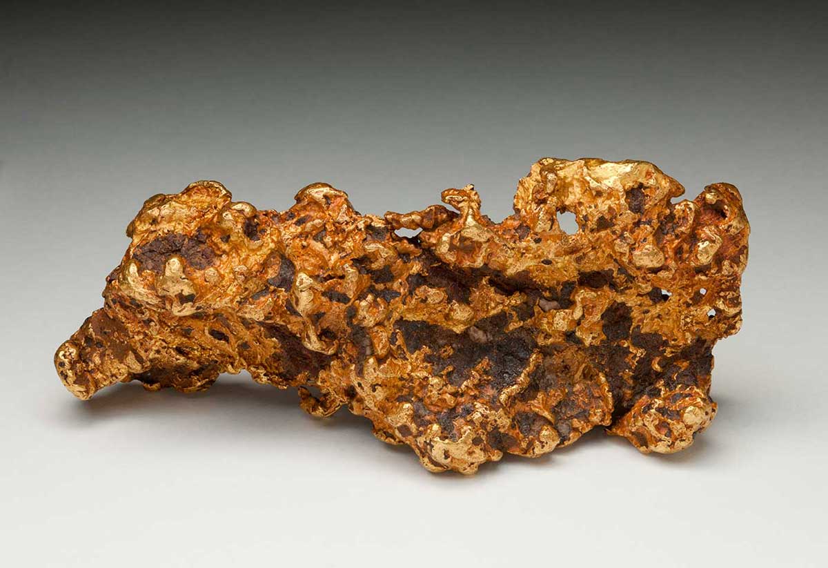 A gold nugget with a rough and irregular shape and surface. - click to view larger image