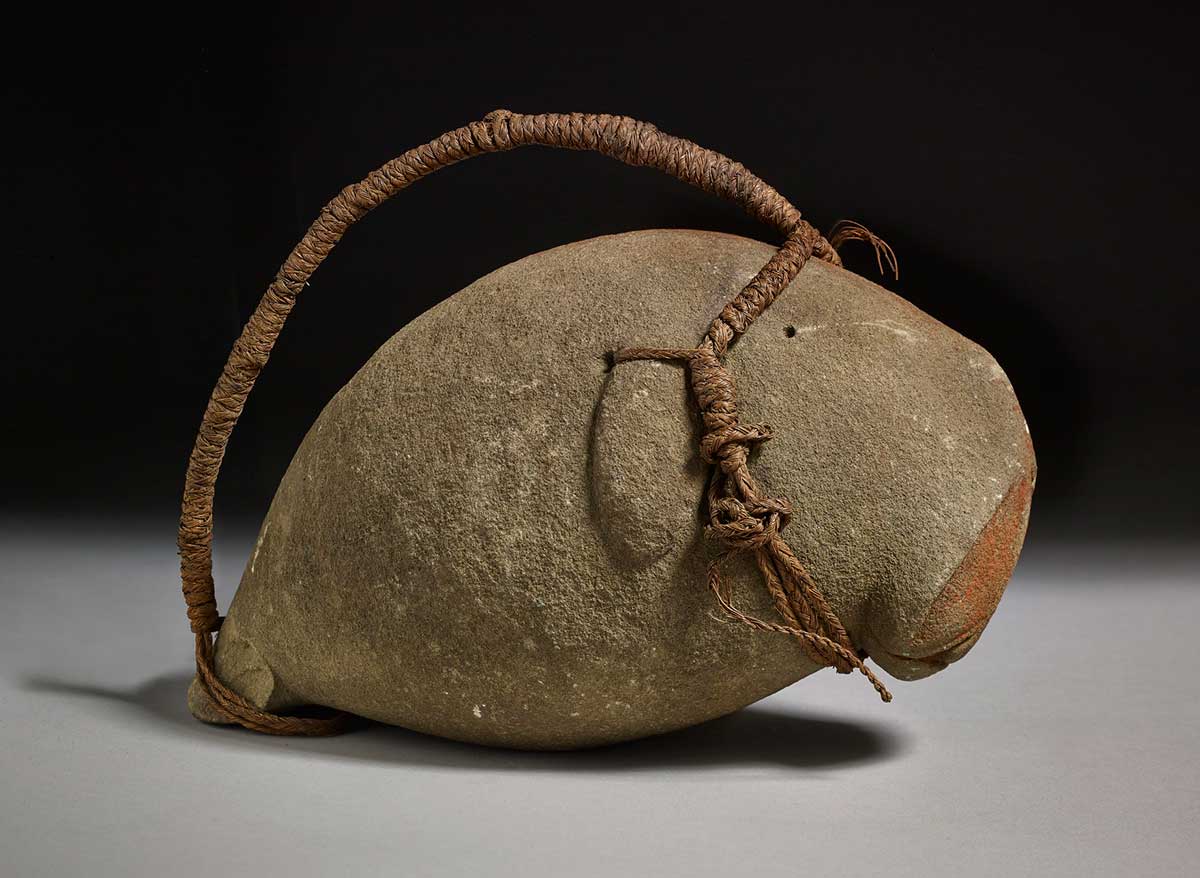 Charm resembling a dugong made from stone, ochre and fibre. - click to view larger image