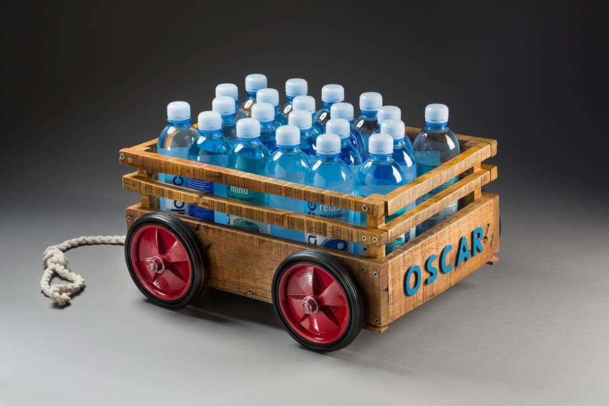Child's toy cart containing water bottles.