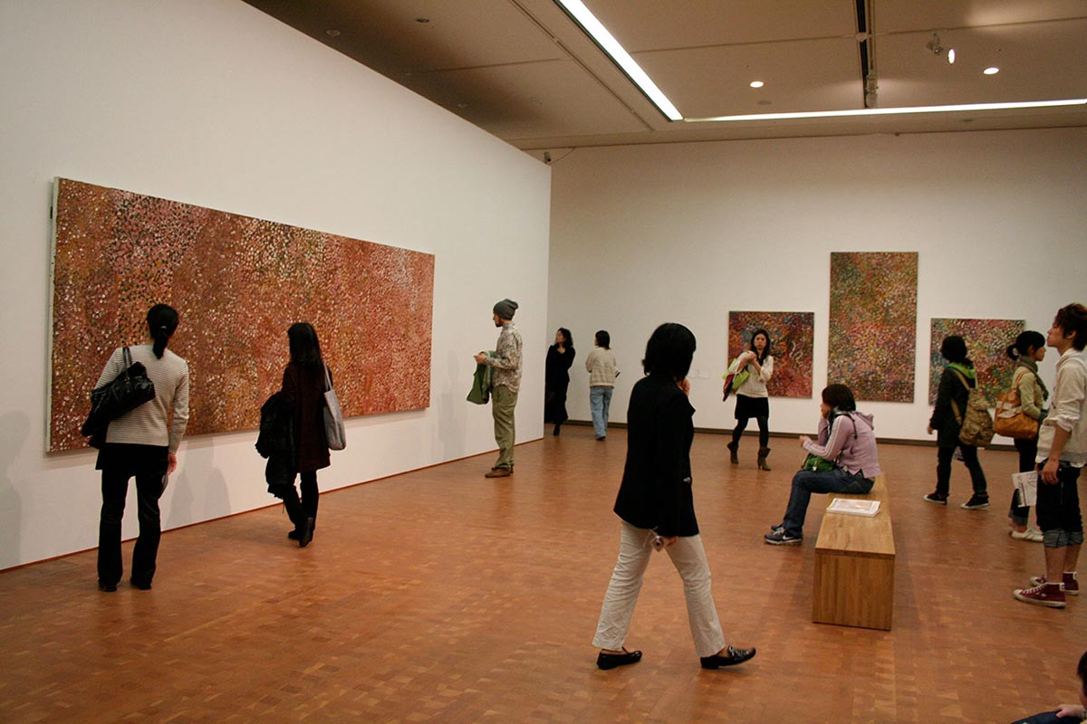Visitors in an exhibition space viewing art works. - click to view larger image