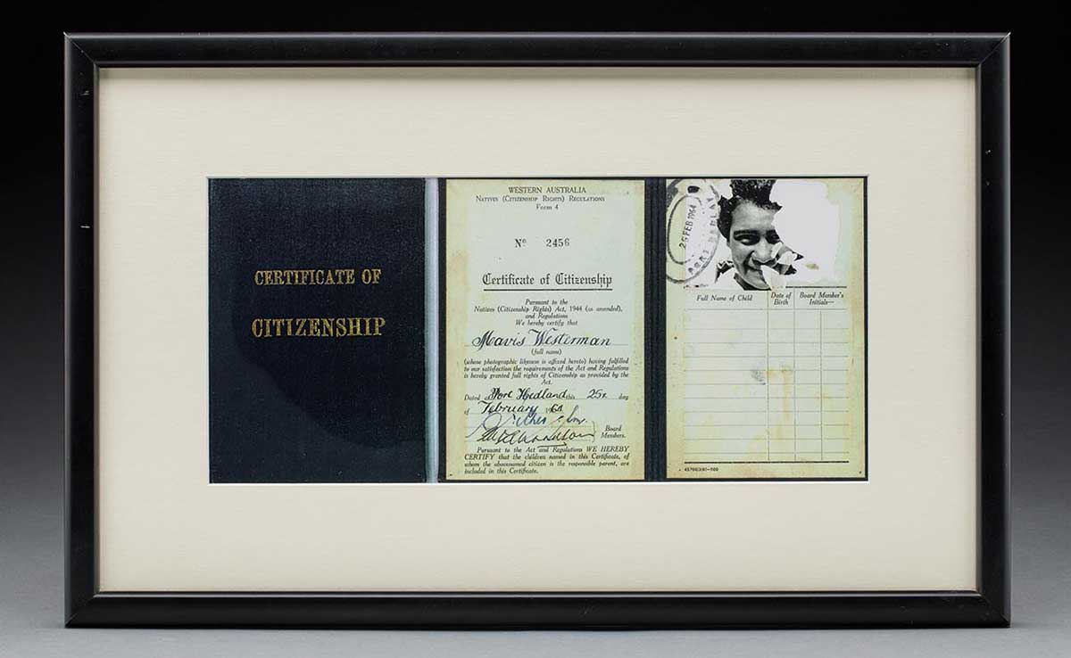 A copy of a citizenship certificate in a black coloured frame. The image is split into three sections. The first section features gold coloured words on a black background and reads 'CERTIFICATE OF / CITIZENSHIP'. The second section features the details of the recipient which read '... No 2456 / Certifiate of Citizenship ... Mavis Westerman ... Dated at Port Headland this 25th day / of February 1964 ...'. The third section features a photograph of the recipient. - click to view larger image