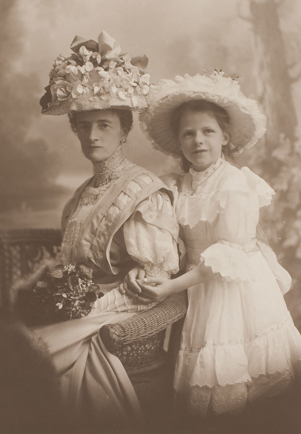 A seated woman with a young girl standing behind her. - click to view larger image