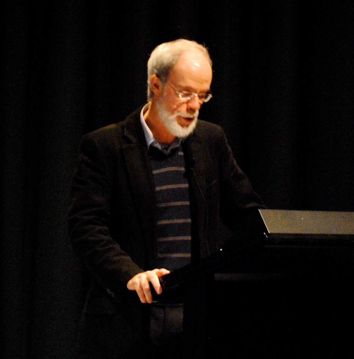 A man stands at a lectern speaking.