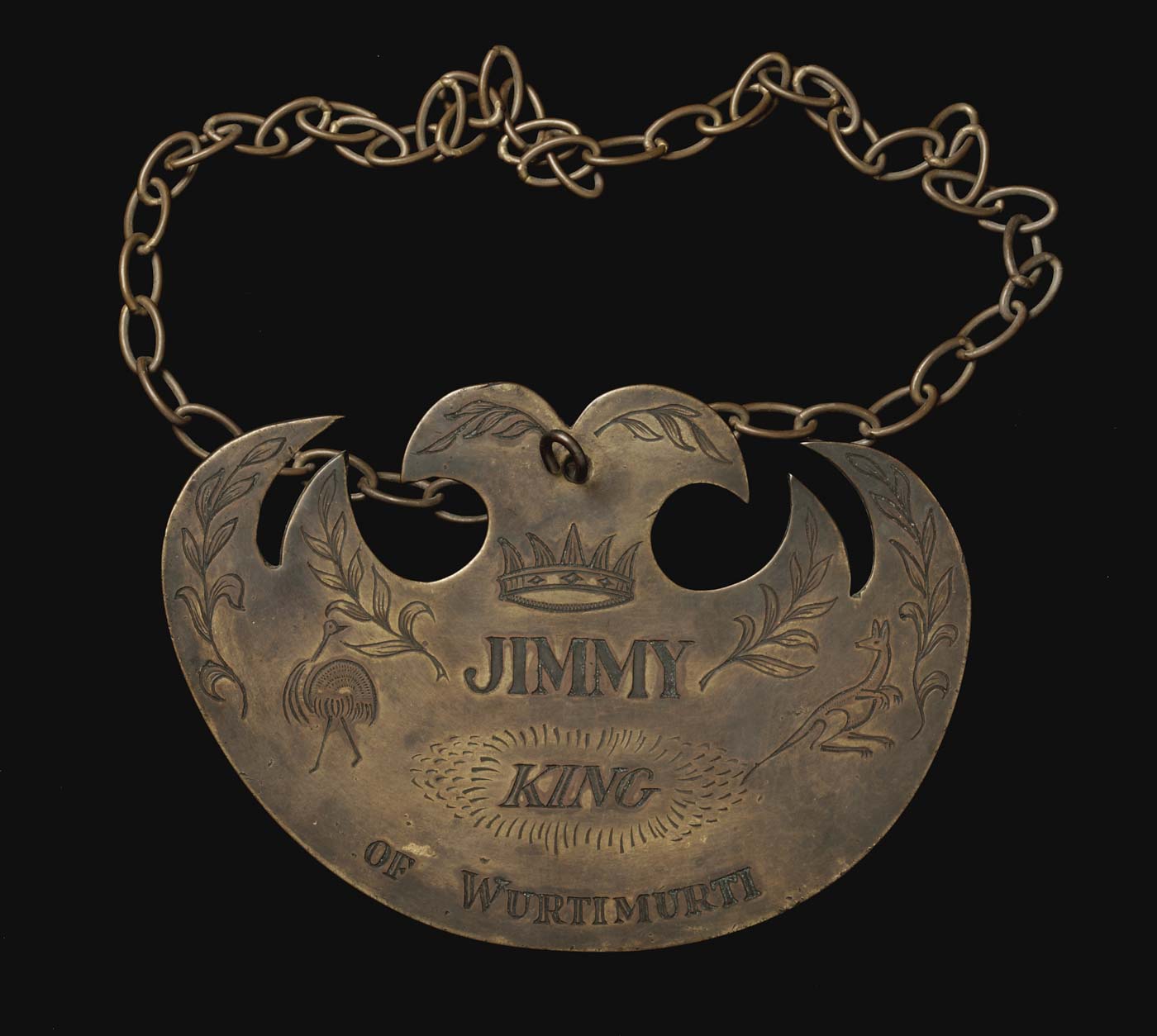 Engraved breastplate with a chain at top and an image of a kangaroo, emu, foliage and a crown. - click to view larger image