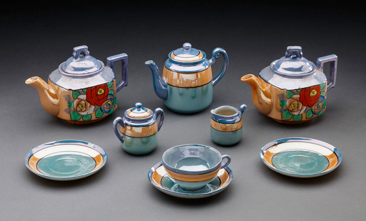 Display featuring a ceramic tea set including three teapots, a sugar basin, a milk jug, a teacup and three teacup saucers. - click to view larger image