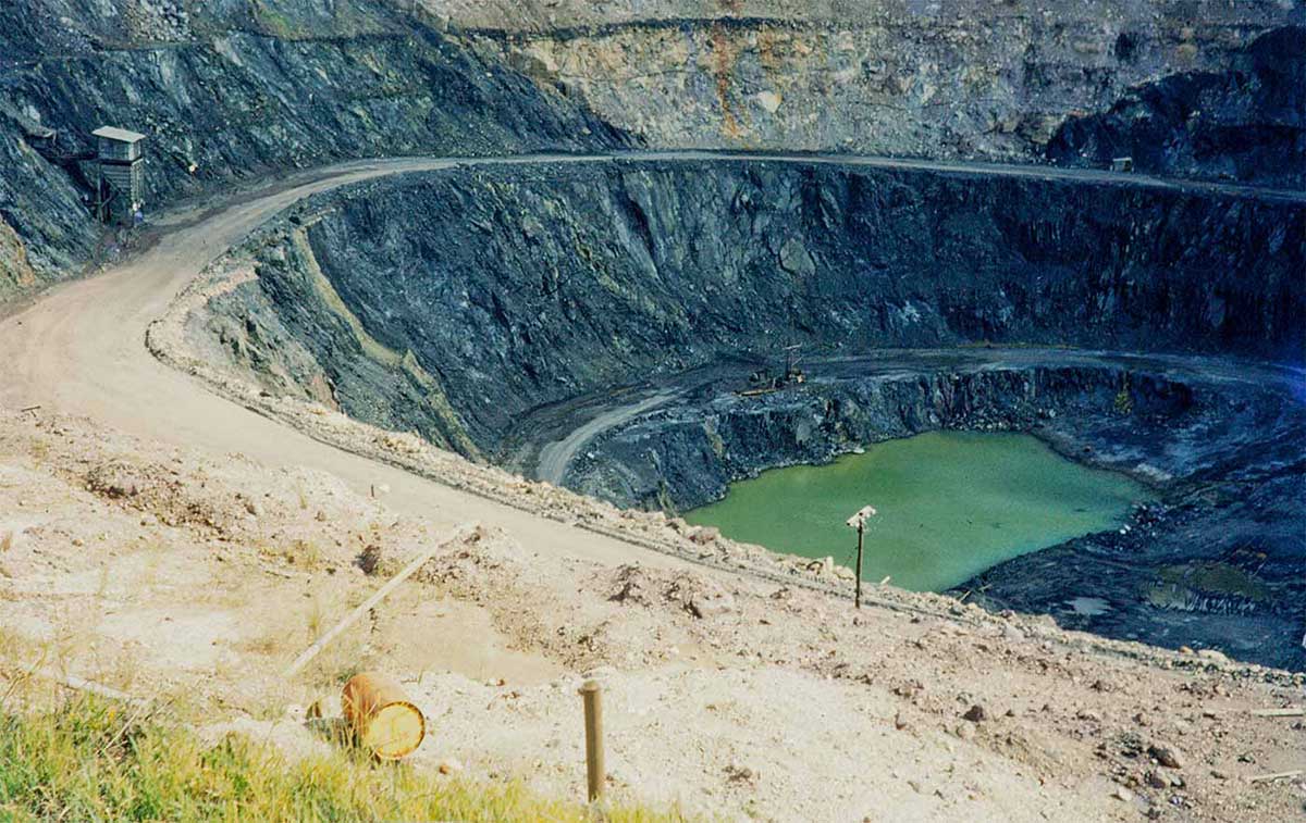 Colour photo of a very large iron ore mining pit.