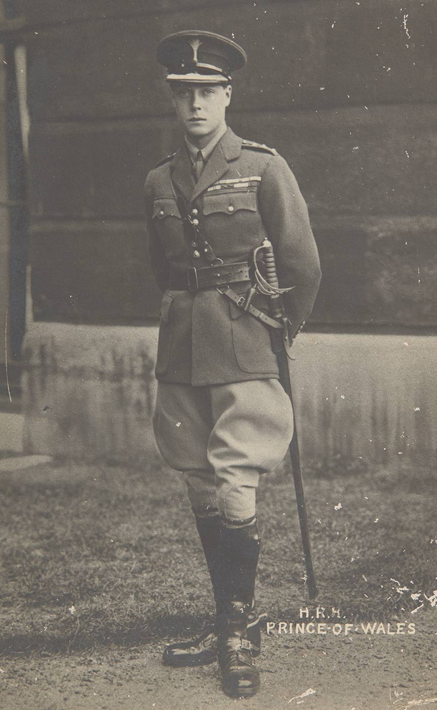 An unused postcard showing a man in military uniform, complete with a sword worn on the right side of his hip. Printed in white ink at the bottom right ar the words 'H.R.H. / PRINCE OF WALES'. There are scratches on the image around the bottom right corner. - click to view larger image