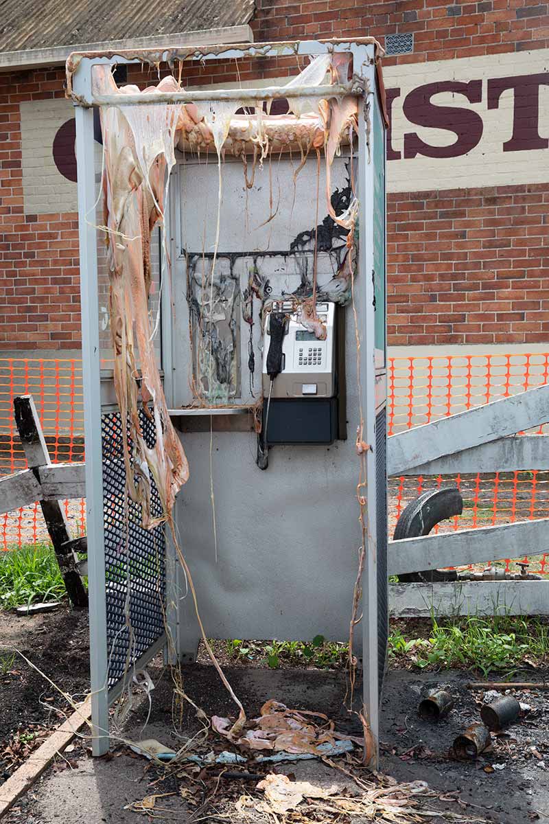 A melted phone booth damaged by fire. - click to view larger image