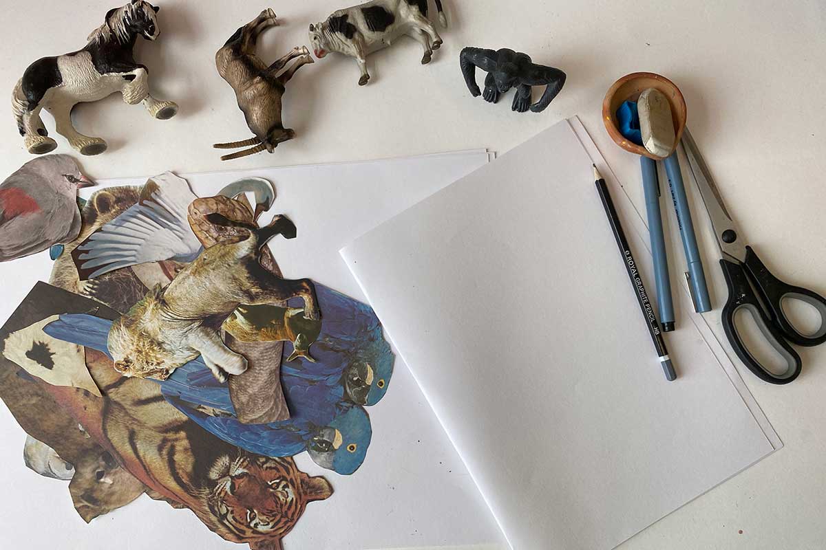Images of various animals cut from paper, alongside animal figurines, a pair of scissors, paper, pencils, pens and an eraser.