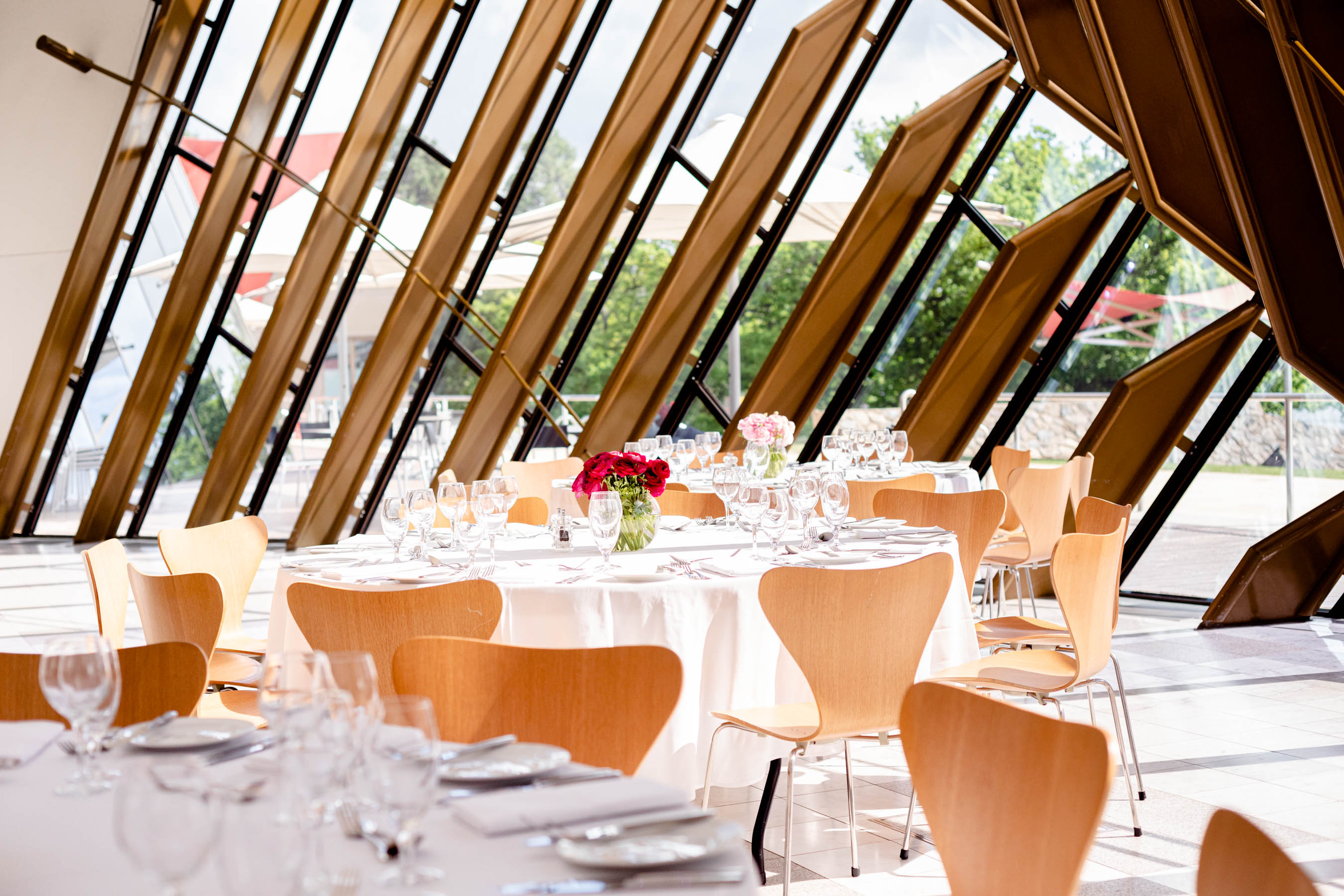 Tables set up for a function in a large bay window.