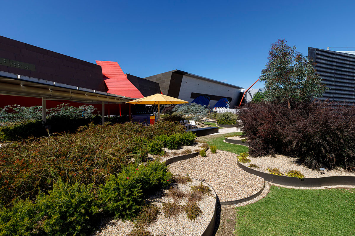 An outdoor museum space featuring landscaped gardens with Australian native plants.