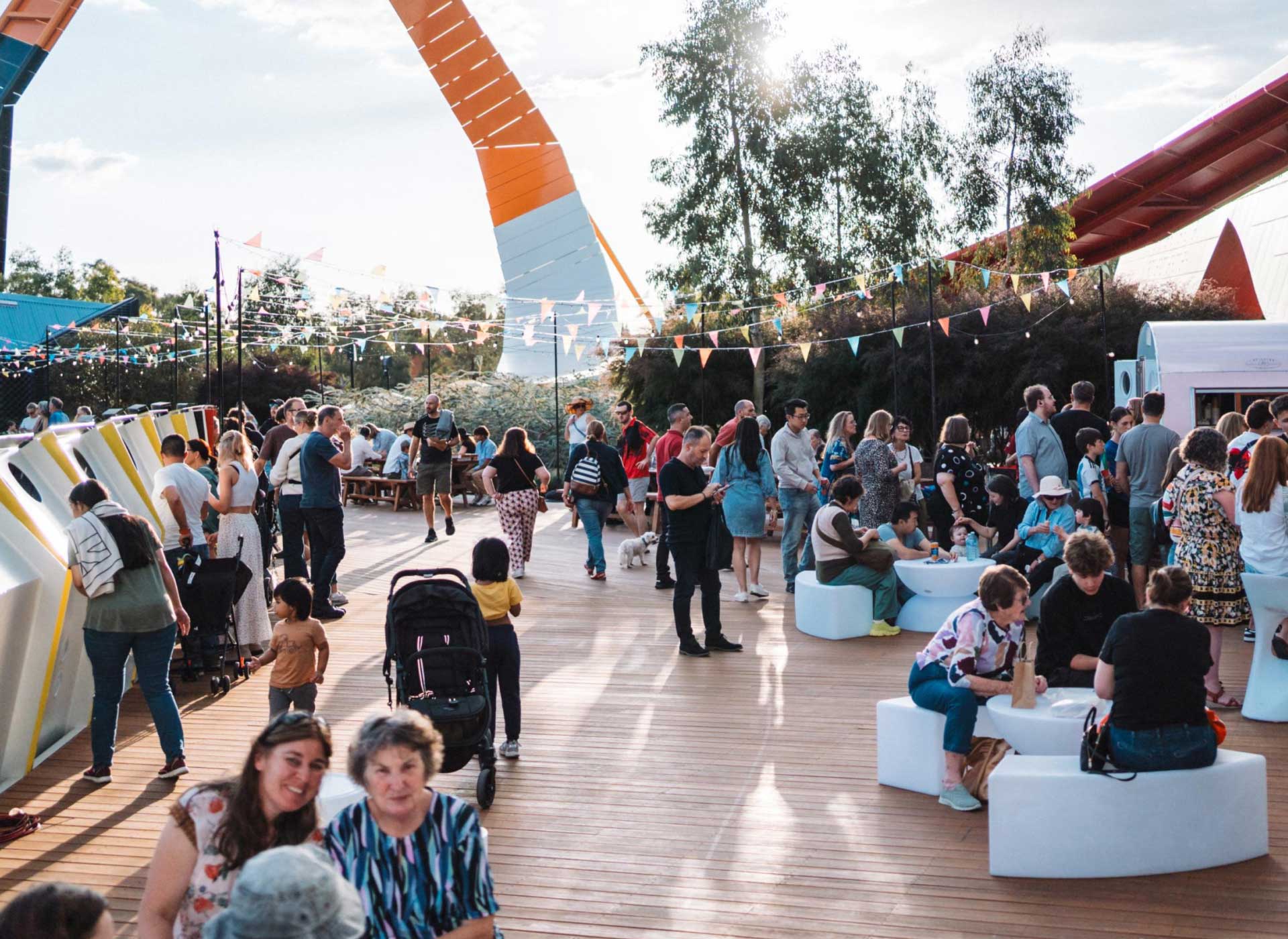 A photograph of a crowd of people on the Museum's wooden deck enjoying a festival at the Museum.