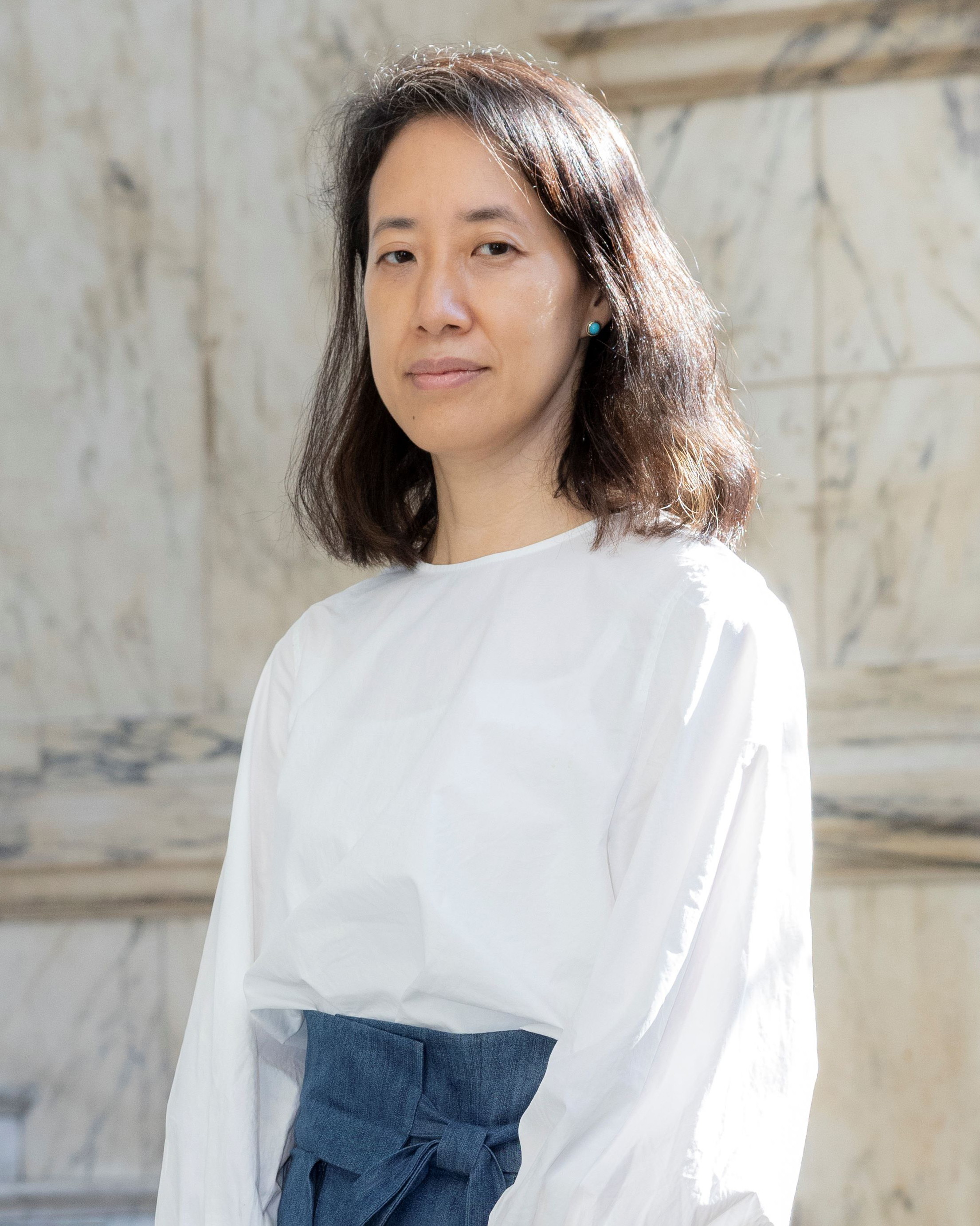 Dr Rosalie Kim. Rosalie is wearing a white shirt, she has brown shoulder length hair.