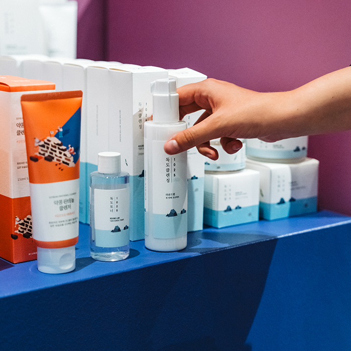 Photograph of bottles of beauty products in front of their boxes.
