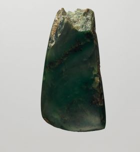 Adze blade made of a light-coloured greenstone (a kind of Jasper or Nephritic stone) with four-edged cross-section and without shoulder neck.