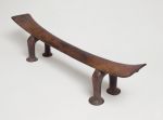 Headrest made of wood, the ‘seat’ is slightly curved and supported by a pair of horseshoe-shaped legs. The ‘seat’ becomes wider from the middle towards both ends.
