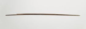 Bow made of brown wood and curved, becoming slightly thinner towards both ends (the string is missing)