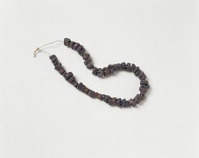 Jewellery & Adornment made from black-brown coconut discs arranged on a string.