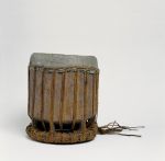 Standing drum with zig-zag lashing. Drum skin made from shark skin fastened with plaited cord of coconut fibres stretched from the cover to the ring-like pedestal.