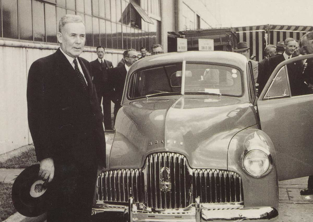Black and white photo of Ben Chifley with a Holden car.