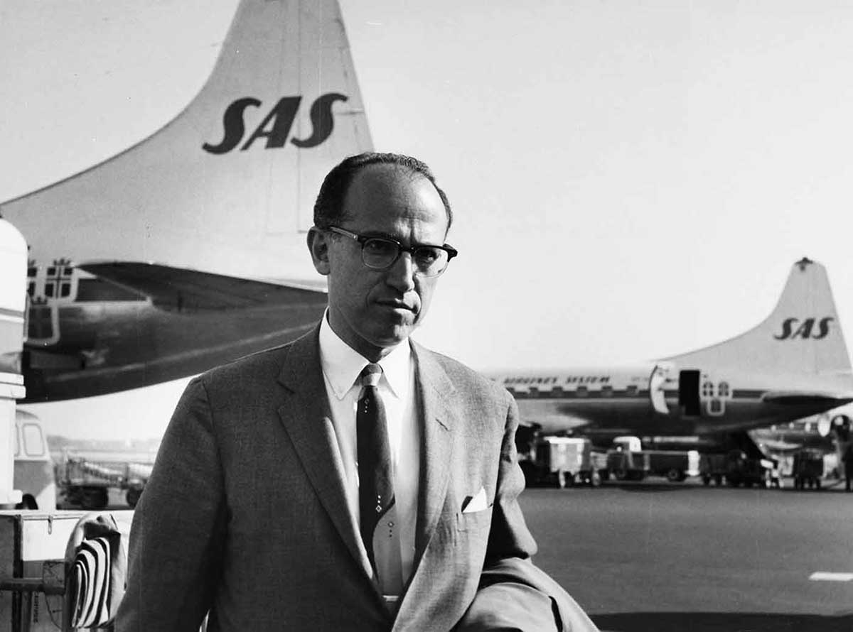 portrait of a serious-looking man of about 40 in a suit, with a receding hairline, wearing glasses - click to view larger image