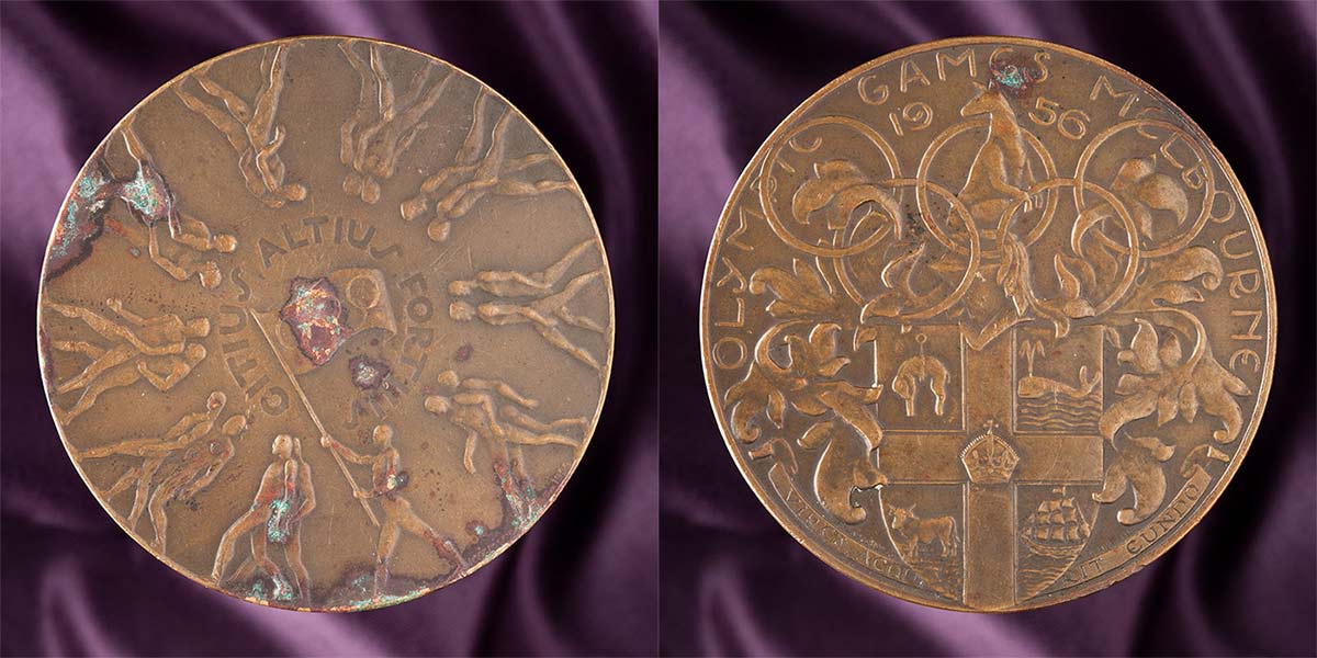 The front and back of Konrads 1956 Olympics participation medal.