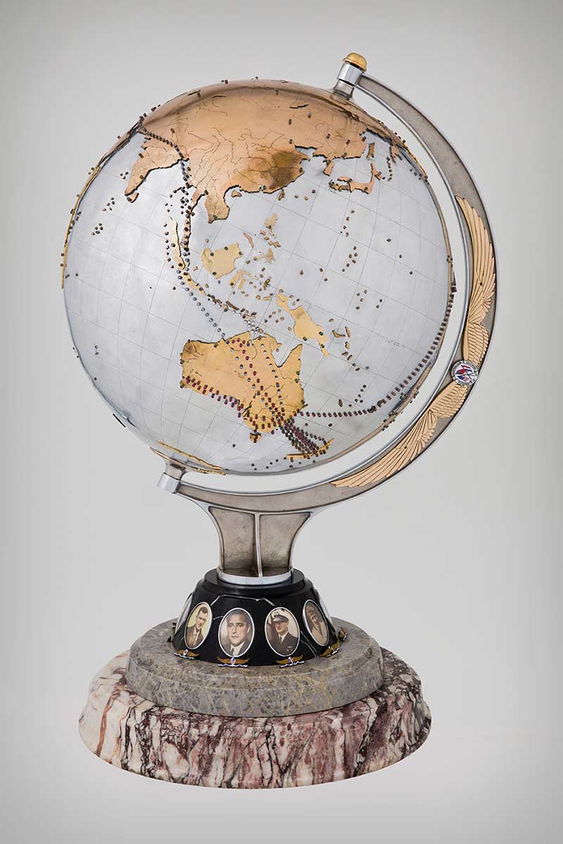 Silver-plated aluminium globe of the world marked with the flights of the Southern Cross. - click to view larger image