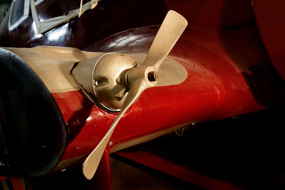 Color photo of a small metal propeller on a wing stub. - click to view larger image