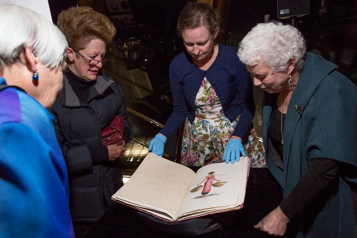 Four women looking at a book.