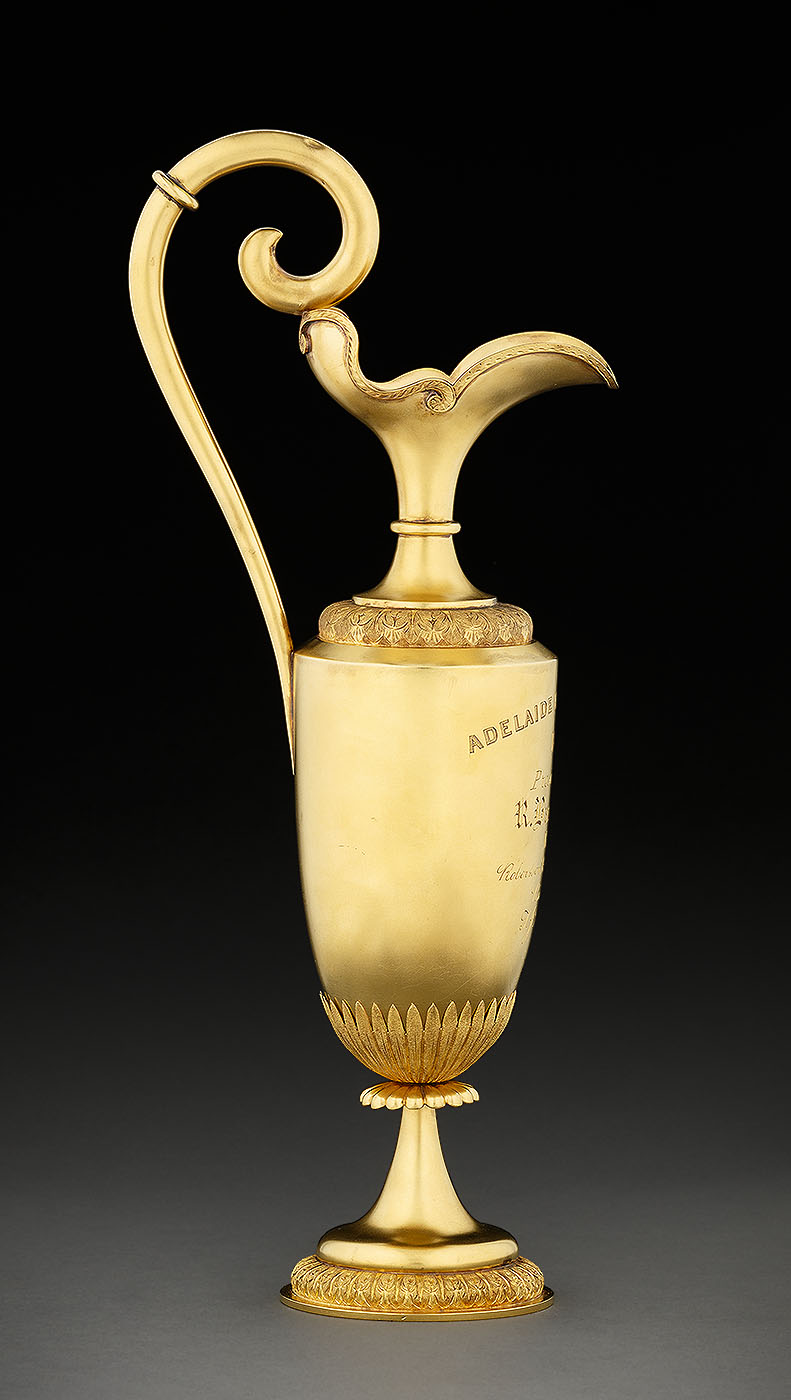 Side view of gold trophy showing curved handle extending above rim. - click to view larger image