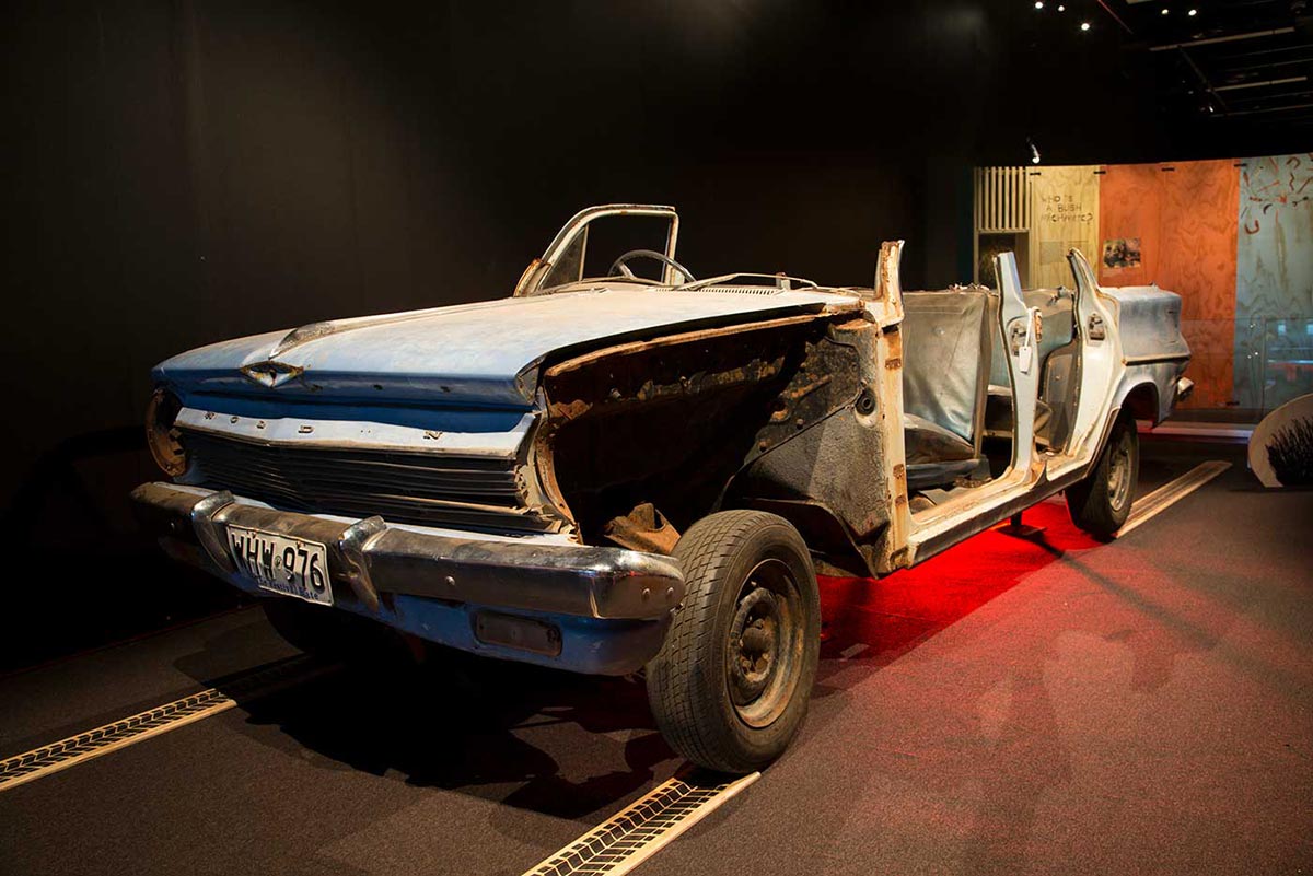 Blue Holden car missing its roof and most passenger side panels. - click to view larger image
