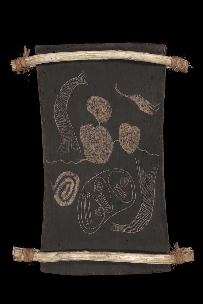 A bark etching supported between two pieces of split wooden restraints. The etching features three skulls and six bones, an emu, two fishnets, a coil shaped pattern to the left lower side and three irregular round shapes represented as lakes. - click to view larger image
