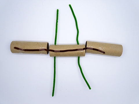 Three cupboard tubes joined together with sticky tape and pipe-cleaners.