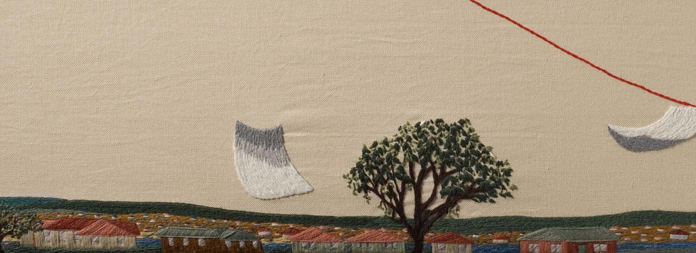 The third panel to 'The Crimson Thread of Kinship' embroidery. This panel features pieces of paper trailing across the sky and over suburbs. - click to view larger image
