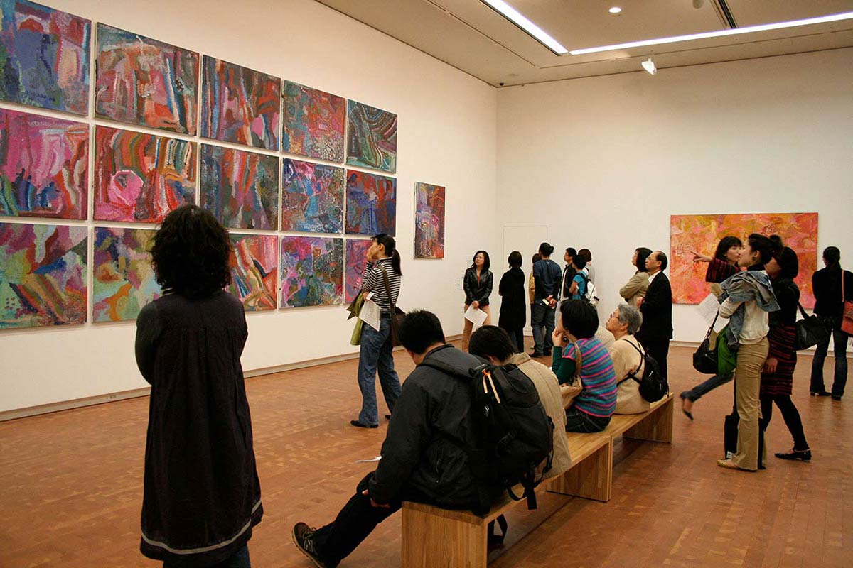 Visitors in an exhibition space viewing art works. - click to view larger image