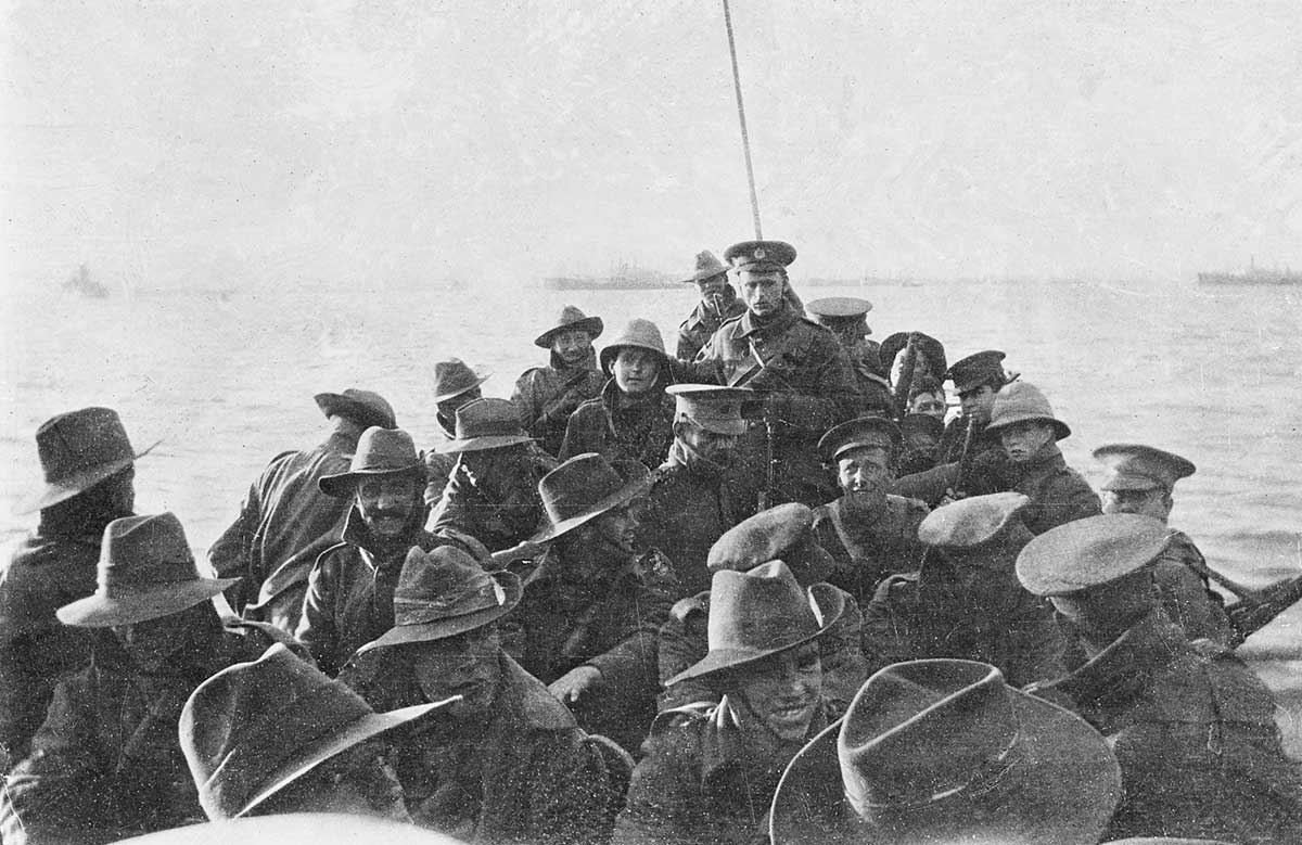 A boat packed with young, smiling men mostly in slouch hats.