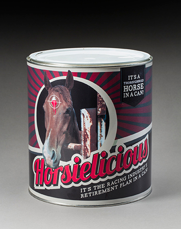 A small can with a white lid and label showing a horse's head with a target marked on its forehead. Text reads 'Horsielicious: It's the racing industry's retirement plan in a can'. - click to view larger image