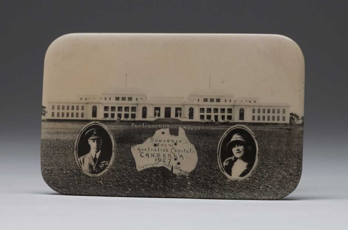 The back of a metal mirror depicting Provisional Parliament House, portraits of the Duke and Duchess, and a map of Australia. - click to view larger image