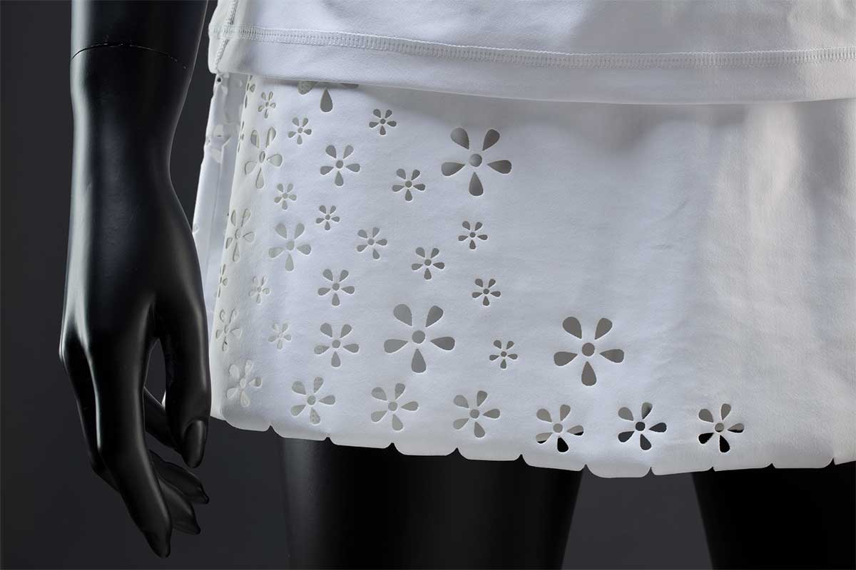 A white tennis Fila 'Trailblazer' skort with laser cut scalloped hem and floral decoration at the front and side. - click to view larger image