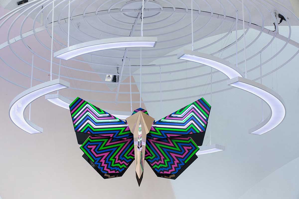Multicoloured bogong moth sculpture hanging from the ceiling.